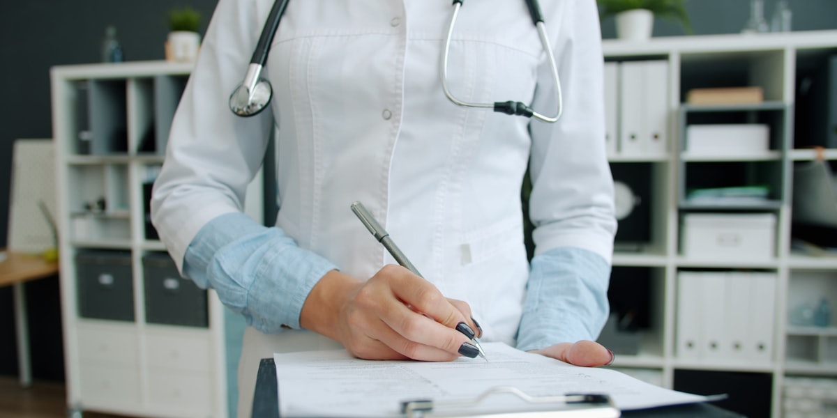Doctor reviewing patient notes with dictation software on a Mac