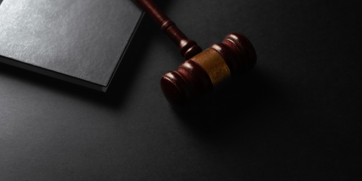 Wooden gavel resting next to legal books on a desk